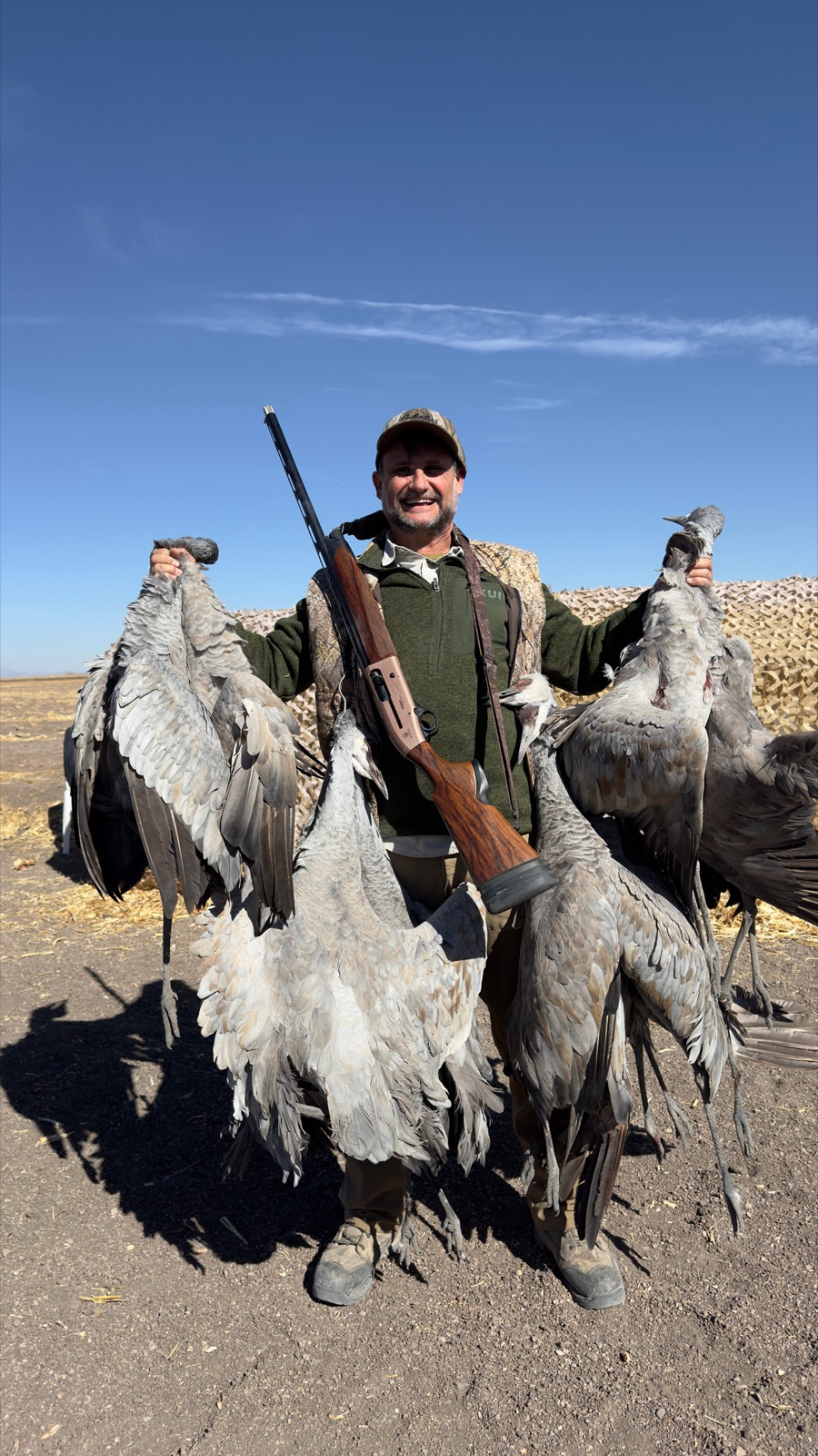 Hunter showing two large sandhill cranes