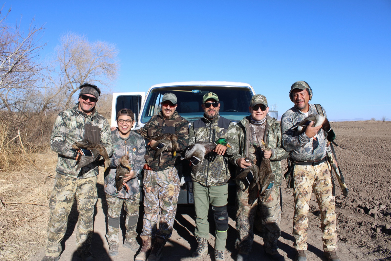 Six hunters at the truck with a duck strap