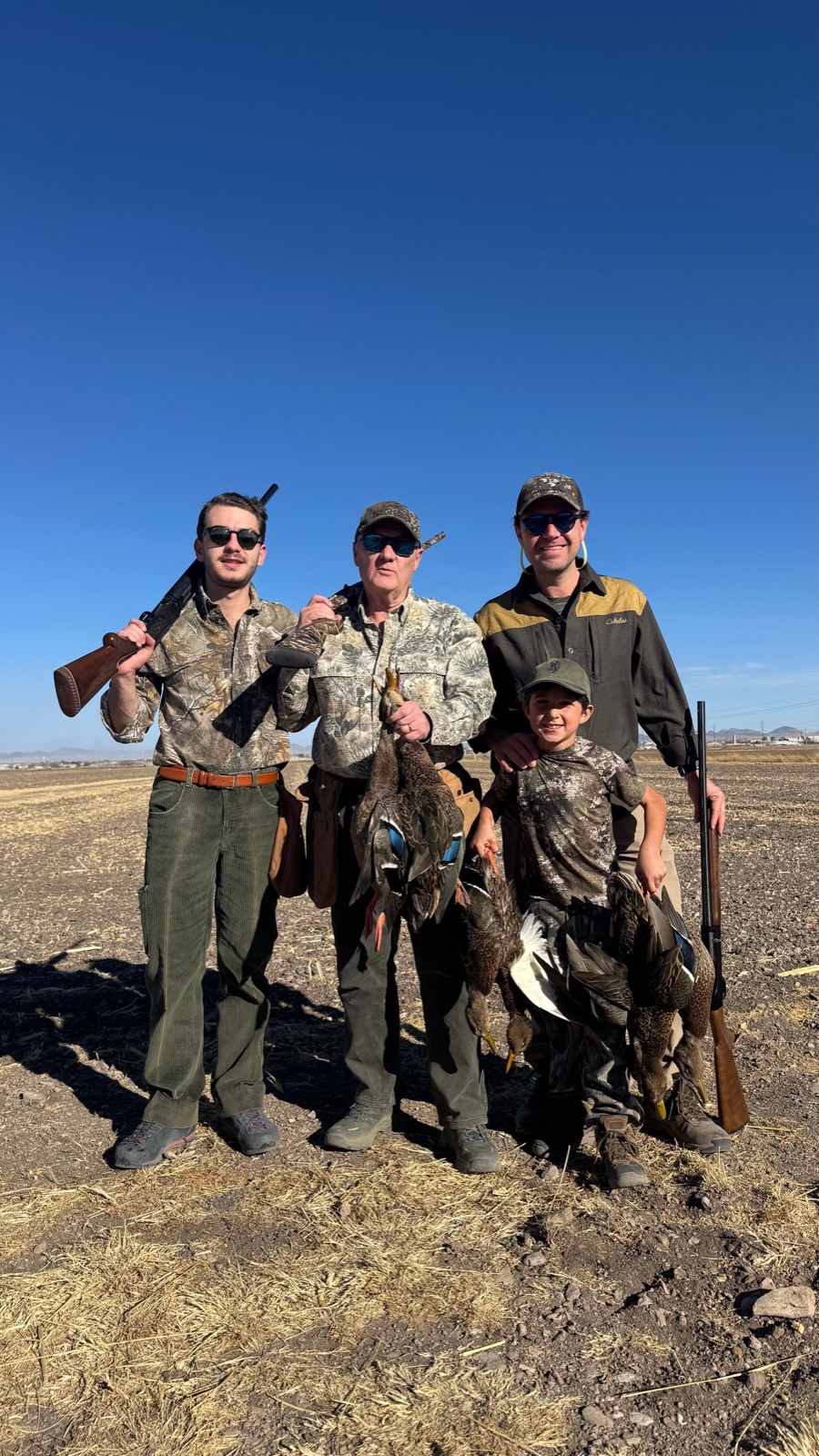 Three generations of hunters — grandfather, father, and grandson with ducks